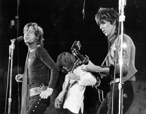 Mick Jagger, left, sings while guitarist Mick Taylor, center, and Keith Richards, right, show just how completely contrasting two different techniques can make a single instrument sound during their performance on Nov. 16, 1969 at the International Amphitheatre. (Dave Nystrom/Chicago Tribune)