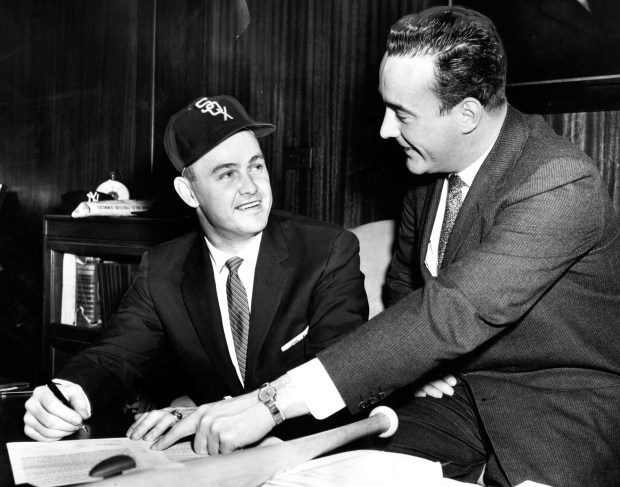 Nellie Fox, left, Chicago White Sox second baseman, signs a contract for an estimated $42,000 as Chuck Comiskey nods approval on Feb. 2, 1959, at Comiskey Park. (Chicago Tribune historical photo)