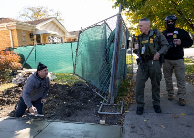 Border Patrol Cmdr. Gregory Bovino makes small talk with a concrete worker after his agents questioned the man for his citizenship documents, Oct. 31, 2025, in Chicago's Edison Park neighborhood. (Brian Cassella/Chicago Tribune)