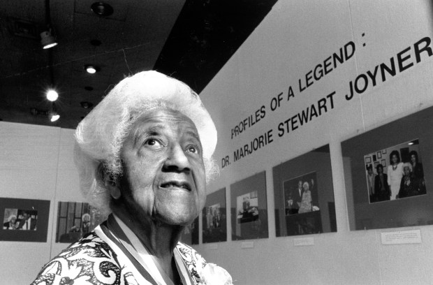 Dr. Marjorie Stewart Joyner stands by an exhibit of her life on display at the A. Montgomery Ward Gallery at the University of Illinois at Chicago on Feb. 15, 1985. (Ovie Carter/Chicago Tribune)