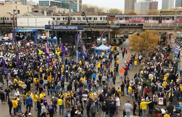 CTA Red Line trains pass above fans on Waveland Avenue before a Northwestern-Michigan football game at Wrigley Field on Nov. 15, 2025, in Chicago. (John J. Kim/Chicago Tribune)