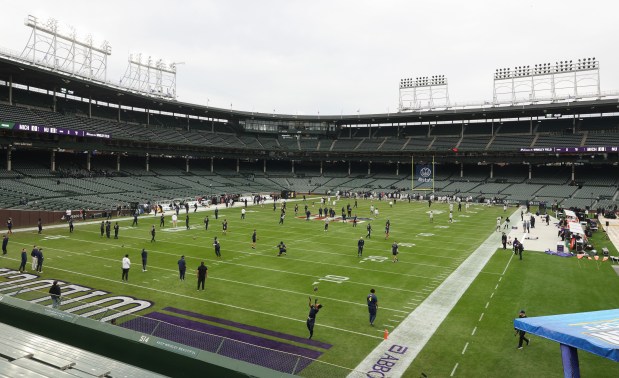 Northwestern and Michigan players warm up for a game at Wrigley Field on Nov. 15, 2025, in Chicago. (John J. Kim/Chicago Tribune)