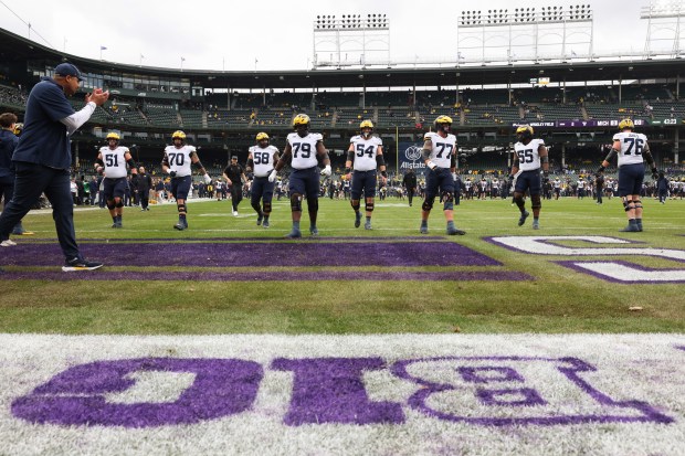 Michigan players warm up for a game against Northwestern at Wrigley Field on Nov. 15, 2025, in Chicago. (John J. Kim/Chicago Tribune)