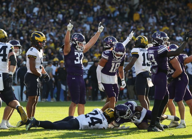 Northwestern defensive back Braden Turner (9) recovers a Michigan fumble in the fourth quarter at Wrigley Field on Nov. 15, 2025, in Chicago. (John J. Kim/Chicago Tribune)