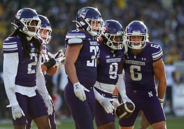 Northwestern defensive back Braden Turner (9) heads to the sideline with teammates after recovering a Michigan fumble in the fourth quarter at Wrigley Field on Nov. 15, 2025, in Chicago. (John J. Kim/Chicago Tribune)