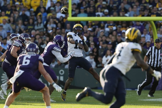 Michigan quarterback Bryce Underwood (19) throws for a first down on 4th-and-10 in their final offensive drive of the fourth quarter against Northwestern at Wrigley Field on Nov. 15, 2025, in Chicago. (John J. Kim/Chicago Tribune)