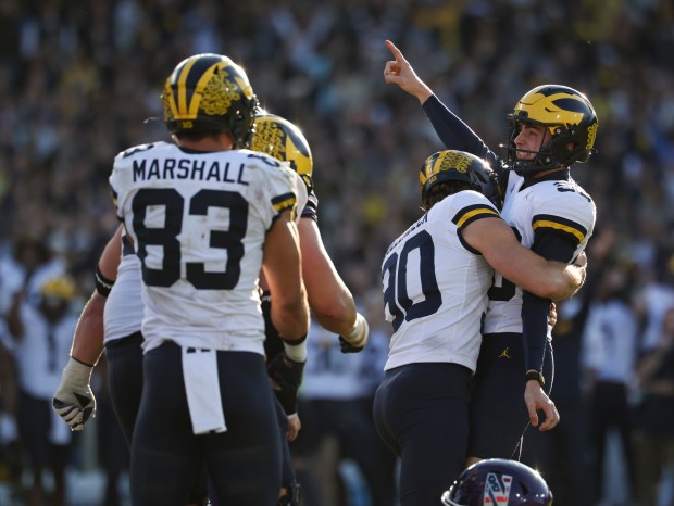 Michigan kicker Dominic Zvada, right, celebrates after making a game-winning field goal for a 24-22 win over Northwestern at Wrigley Field on Nov. 15, 2025, in Chicago. (John J. Kim/Chicago Tribune)