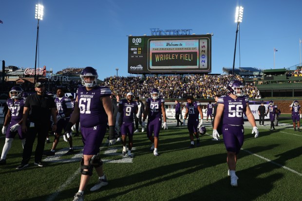 Northwestern players head to the locker room after a 24-22 loss to Michigan at Wrigley Field on Nov. 15, 2025, in Chicago. (John J. Kim/Chicago Tribune)