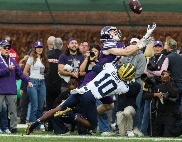 Northwestern wide receiver Griffin Wilde (17) reaches for the ball as Michigan defensive back Zeke Berry (10) brings Wilde down in the first quarter at Wrigley Field on Nov. 15, 2025, in Chicago. (John J. Kim/Chicago Tribune)