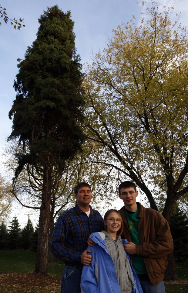 Harlen Weivoda stands alongside daughter, Kelsey, 11, and son, Ian, 15, on Oct. 31, 2009, in front of the 55-foot spruce they donated to be the city's Christmas tree to be displayed in Daley Plaza. (William DeShazer/Chicago Tribune)