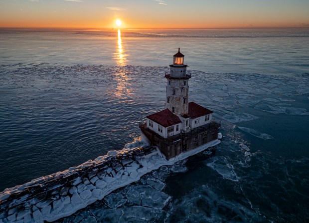 Ice forms around the Chicago Harbor Lighthouse on Lake Michigan after sunrise on Jan. 21, 2024, following a week with temperatures around zero. (Brian Cassella/Chicago Tribune)