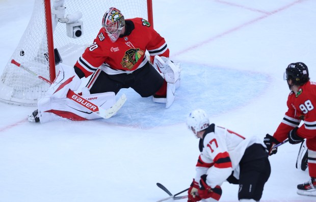 Blackhawks goaltender Spencer Knight is unable to stop the puck as Devils defenseman Simon Nemec scores a goal in the second period Wednesday, Nov. 12, 2025, at the United Center. (Chris Sweda/Chicago Tribune)