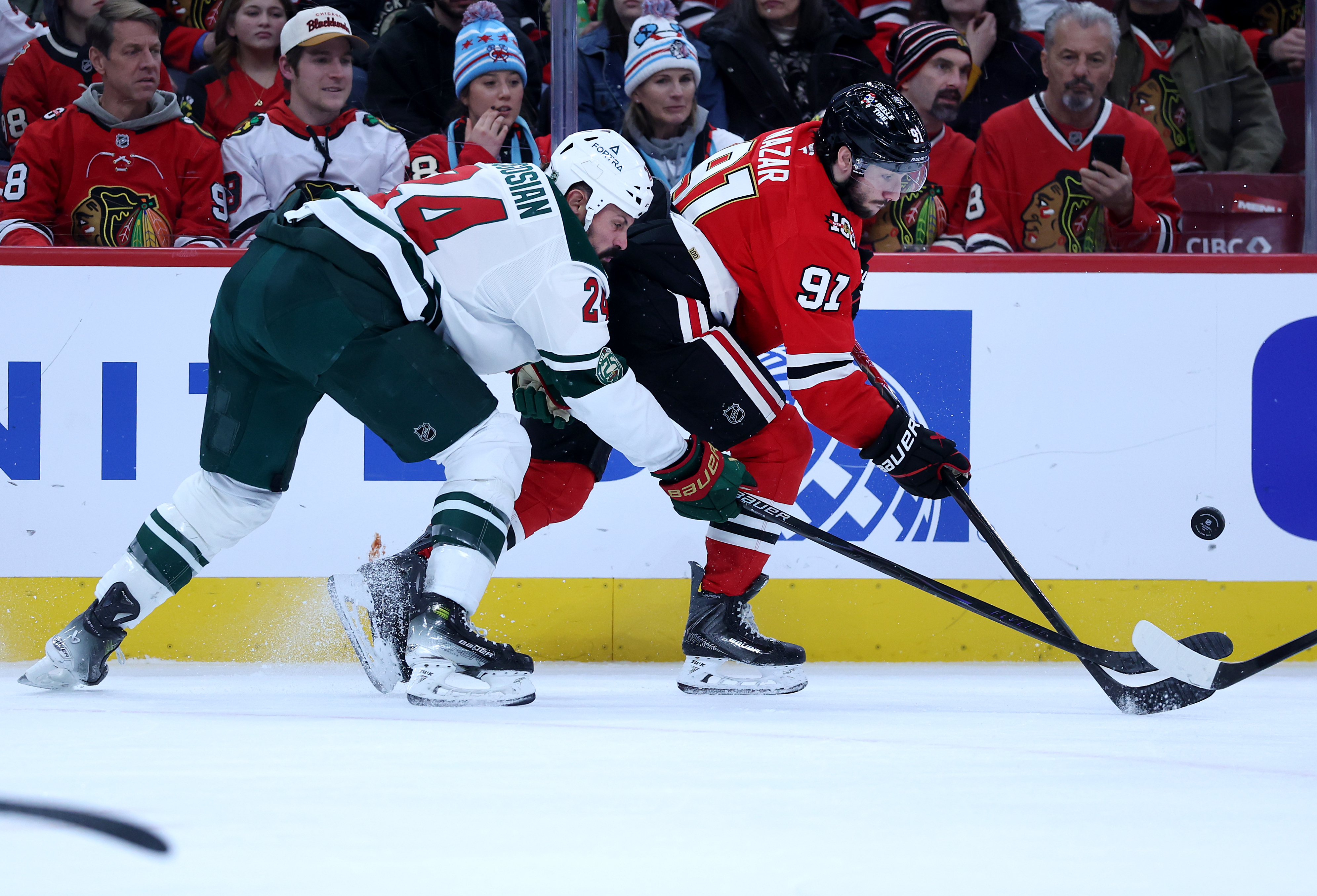 Minnesota Wild defenseman Zach Bogosian (24) and Chicago Blackhawks center Frank Nazar (91) battle along the boards in the first period of a game at the United Center in Chicago on Nov. 26, 2025. (Chris Sweda/Chicago Tribune)