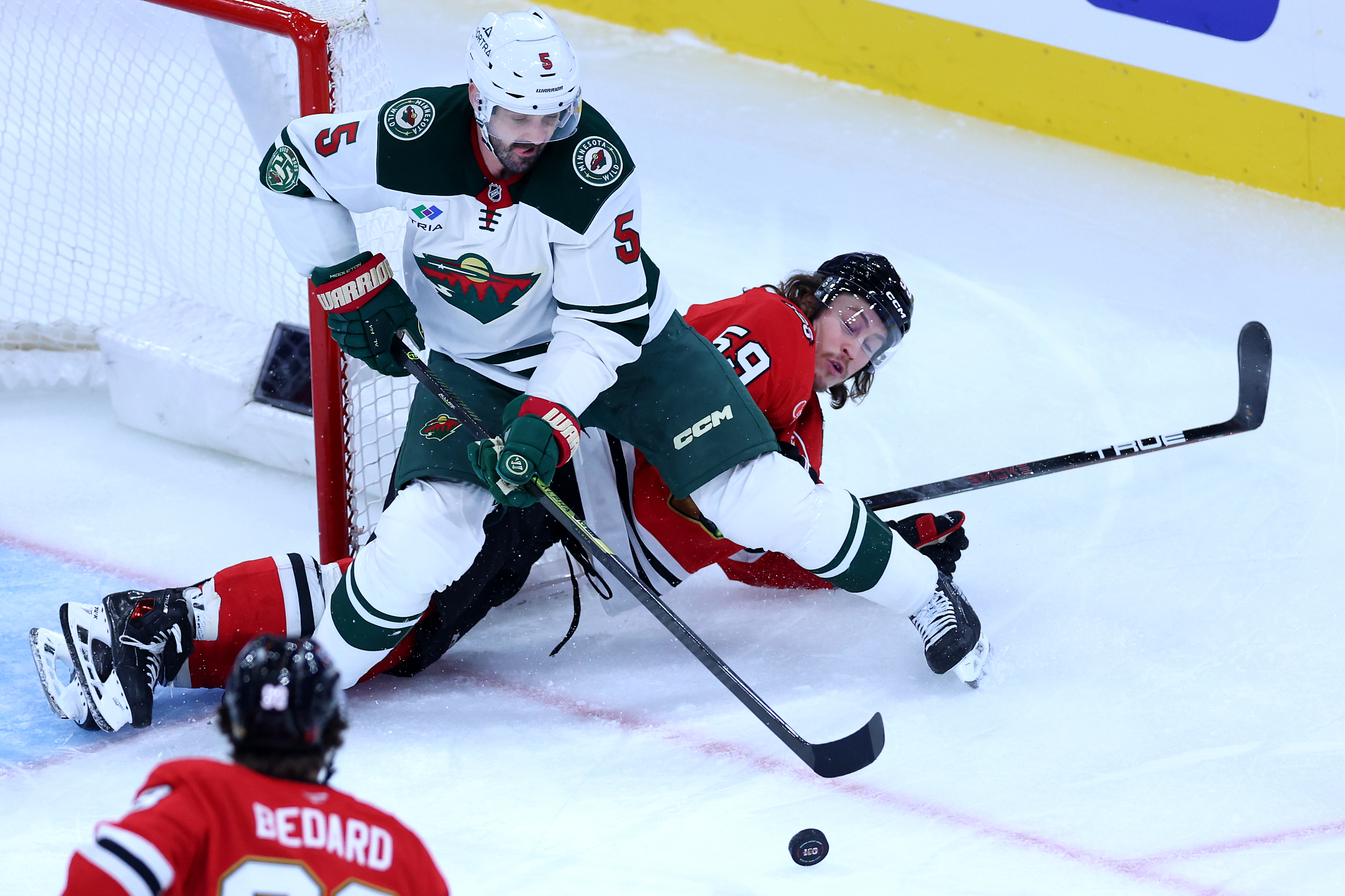 Minnesota Wild defenseman Jake Middleton (5) takes control of the puck in front of Chicago Blackhawks left wing Tyler Bertuzzi (59) in the second period of a game at the United Center in Chicago on Nov. 26, 2025. (Chris Sweda/Chicago Tribune)