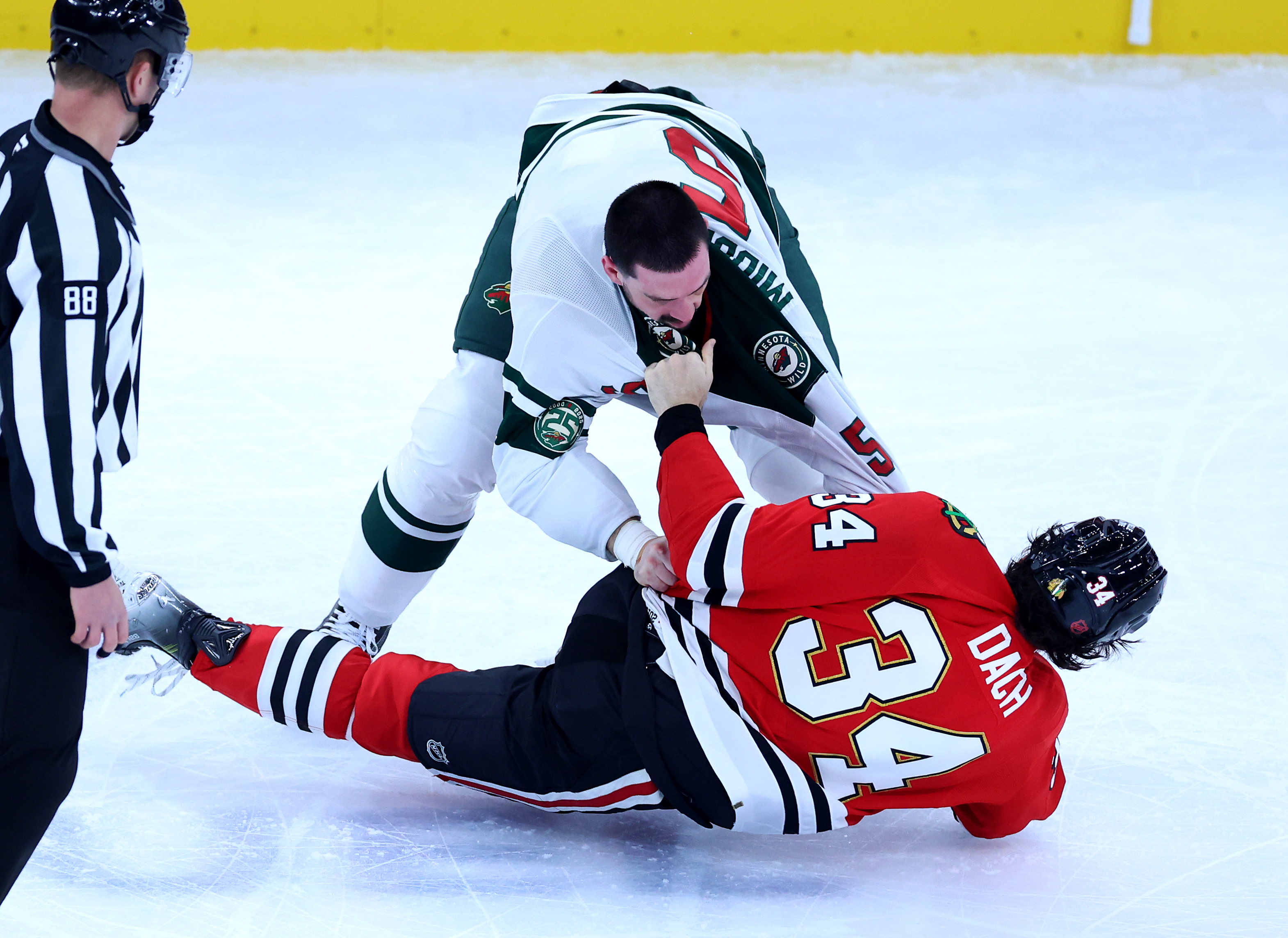 Minnesota Wild defenseman Jake Middleton (5) and Chicago Blackhawks center Colton Dach (34) fight in the second period of a game at the United Center in Chicago on Nov. 26, 2025. (Chris Sweda/Chicago Tribune)