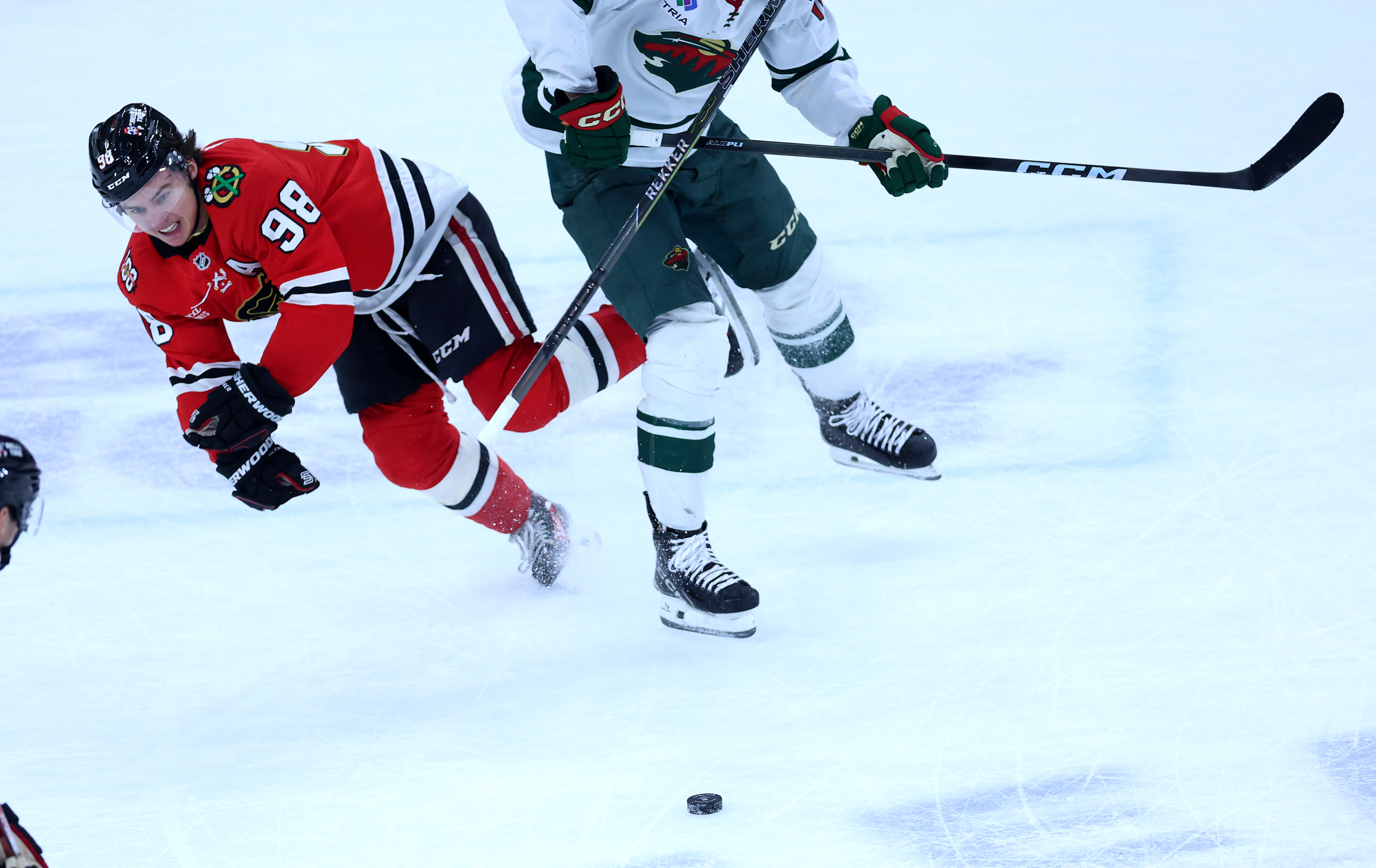 Chicago Blackhawks center Connor Bedard (98) is knocked to the ice in overtime of a game against the Minnesota Wild at the United Center in Chicago on Nov. 26, 2025. (Chris Sweda/Chicago Tribune)