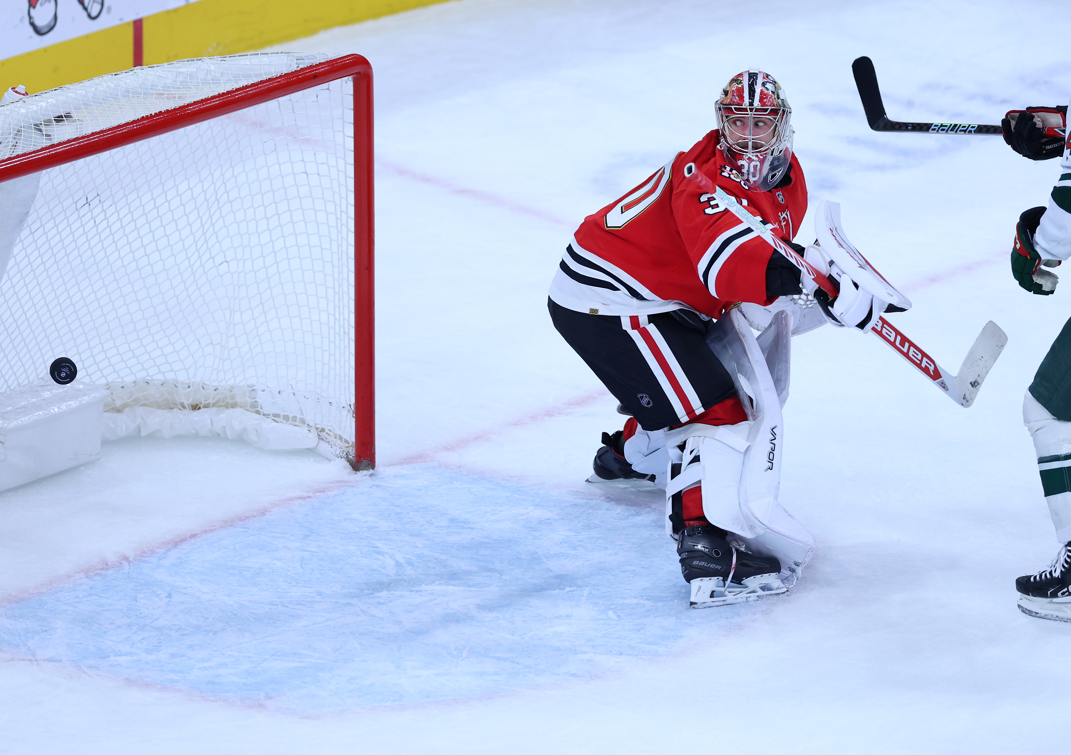 Chicago Blackhawks goaltender Spencer Knight (30) is unable to stop the puck as Minnesota Wild defenseman Brock Faber scores a goal in the second period of a game at the United Center in Chicago on Nov. 26, 2025. (Chris Sweda/Chicago Tribune)