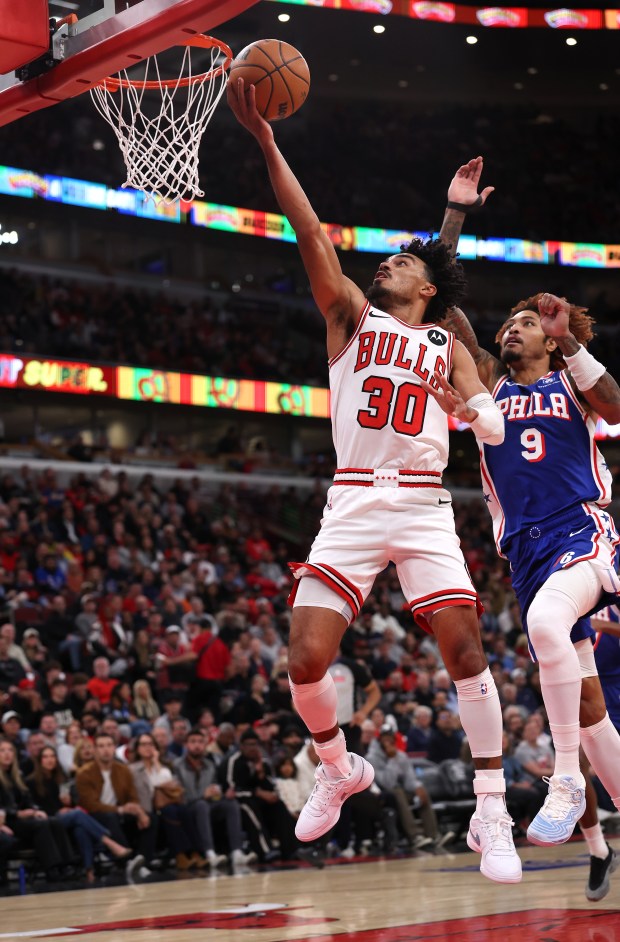 Chicago Bulls guard Tre Jones (30) drives in for a layup on Philadelphia 76ers forward/guard Kelly Oubre Jr. (9) in the first half of a game at the United Center in Chicago on Nov. 4, 2025. (Chris Sweda/Chicago Tribune)