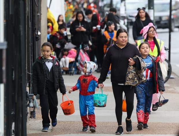 Trick-or-treaters walk on West 26th Street in the Little Village neighborhood of Chicago on Halloween, Oct. 31, 2025. (John J. Kim/Chicago Tribune)
