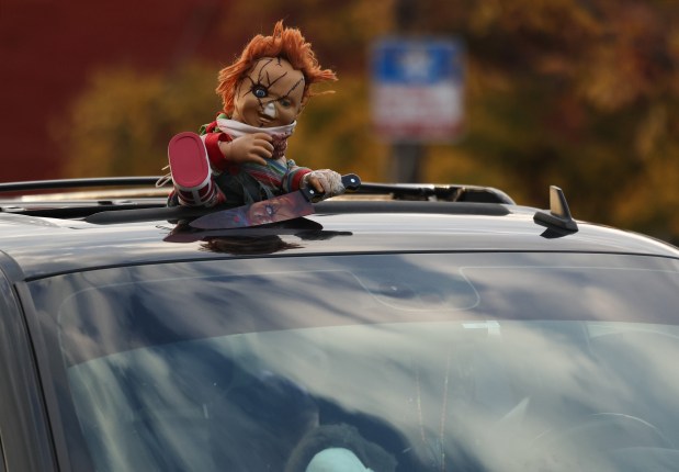 A Chucky doll is placed over a car sunroof on West 26th Street in the Little Village neighborhood of Chicago on Halloween. (John J. Kim/Chicago Tribune)