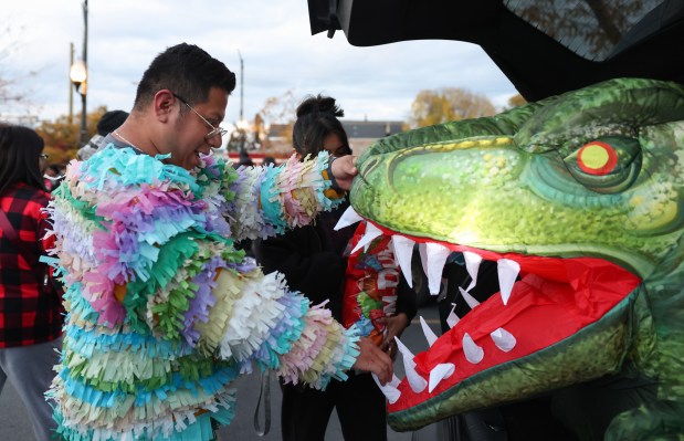 Margarito Perucho assembles a decoration to the back of a vehicle before handing out candy for trick-or-treaters on West 26th Street in the Little Village neighborhood on Halloween in Chicago, Oct. 31, 2025. (John J. Kim/Chicago Tribune)