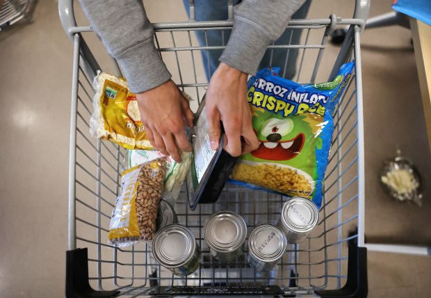 Kennedy-King College student Oscar Rosales, 19, pulls items out of his cart while bagging his food at the Healthy Student Market pantry on campus in Chicago's Englewood neighborhood, Nov. 6, 2025. (Chris Sweda/Chicago Tribune)