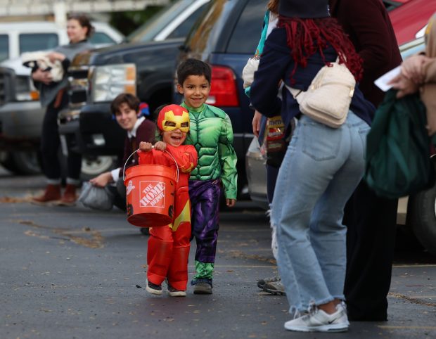 Brothers Angel and Jesse Salinas, 6 and 3 respectively, walk through the trick-or-treat line outside in West Chicago on Oct. 31, 2025. Members of the West Chicago Angels and Christ Our Advocate Church along with students from Wheaton College organized a safe trick-or-treat event for families who reside in areas heavily targeted by federal agents. (Stacey Wescott/Chicago Tribune)