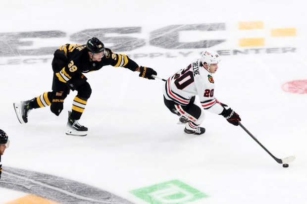 Boston Bruins center Morgan Geekie (39) and Chicago Blackhawks center Ryan Greene (20) chase the puck during the second period of an NHL hockey game, Thursday, Oct. 9, 2025, in Boston. (AP Photo/Mark Stockwell)