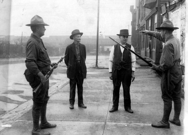 A soldier tells a man to back up during the...