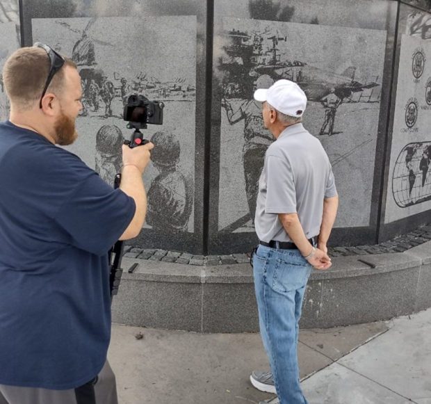 Cinematographer Art Swanlund films Ralph Galati with photos etched on the Veterans Memorial in Newtown Square. (AMERICAN VETERANS MEDIA)
