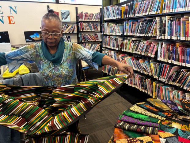 Olivia Faison opens one of the cupulanas she was selling at the Black Saturday Extravaganza that she had bought in Mozambique to sell at the event. (KATHLEEN E. CAREY - DAILY TIMES)
