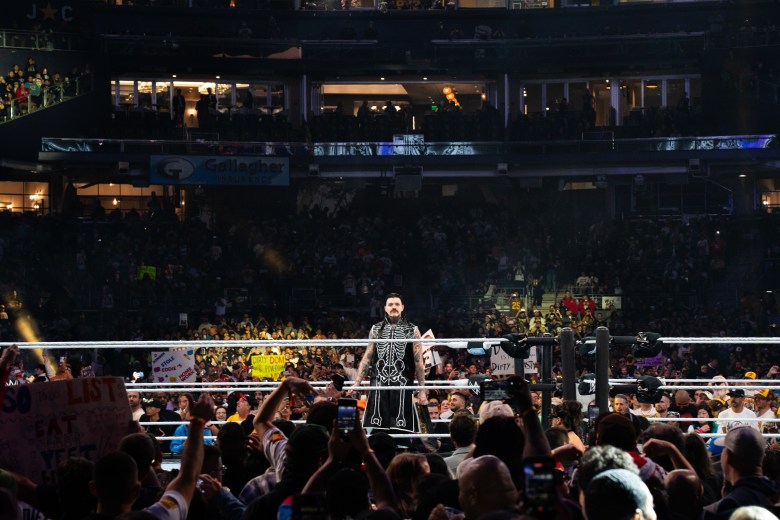 A wrestler in a ring wearing a skeleton cloak