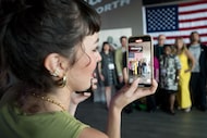 A woman takes a photograph at the Academy Award qualifying premiere of the extended cut of...
