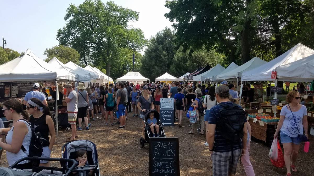 people shopping and buying food at Green City Market, a farmer's market in Lincoln Park, Chicago, IL August 11, 2018