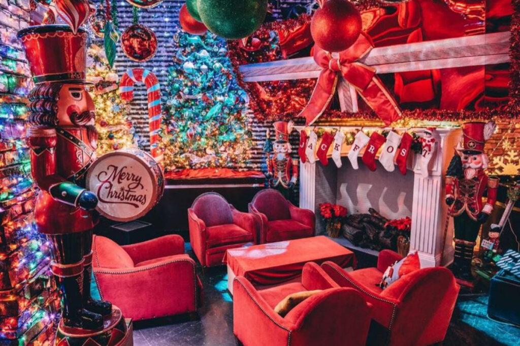 Image shows the interior of Frosty's Christmas bar in Houston with red velvet chairs, tinsel, and lights.