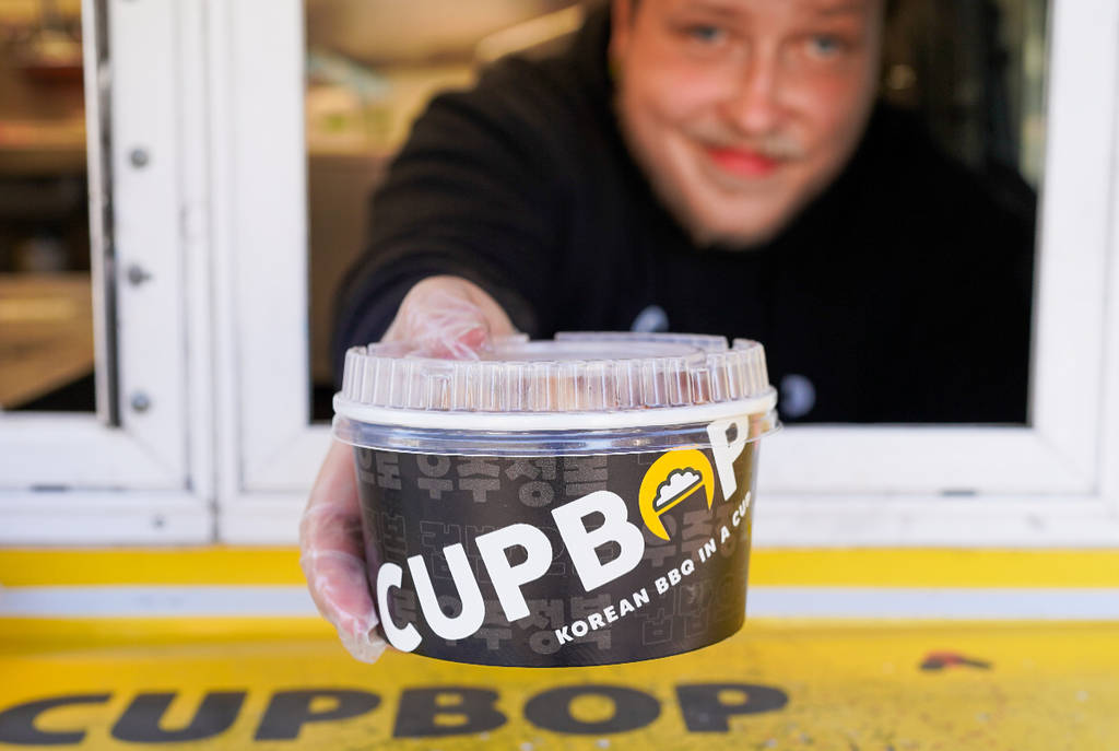 Image shows a server presenting a Cubpop Korean BBQ cup.