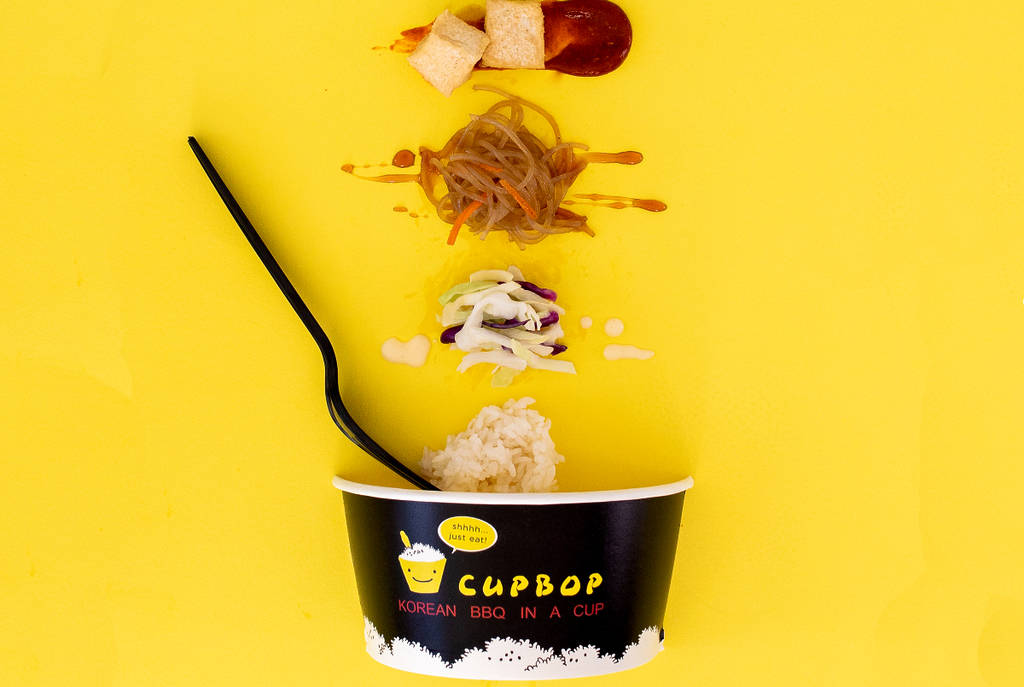 Image shows the Cubpop cup with food options placed above it.