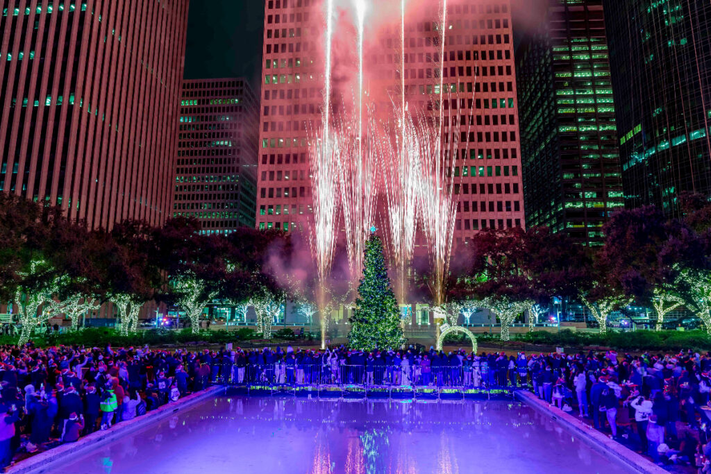 Image shows fireworks shooting around a Christmas tree at Hermann Square in Houston for Deck the Hall: Mayor's Holiday Tree Light Concert