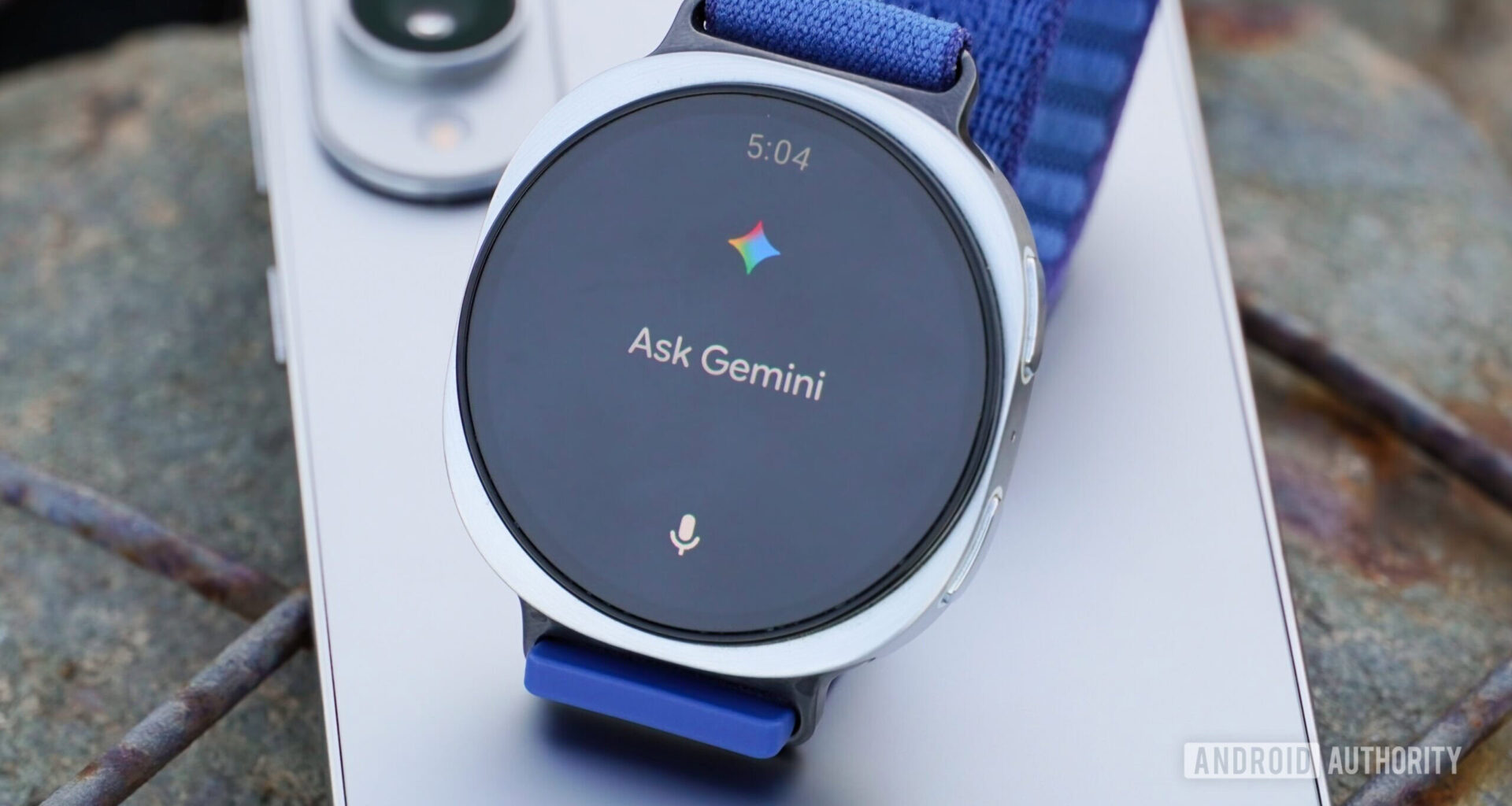 A close-up of Gemini on a Galaxy Watch 8 atop a Galaxy S25 Edge.