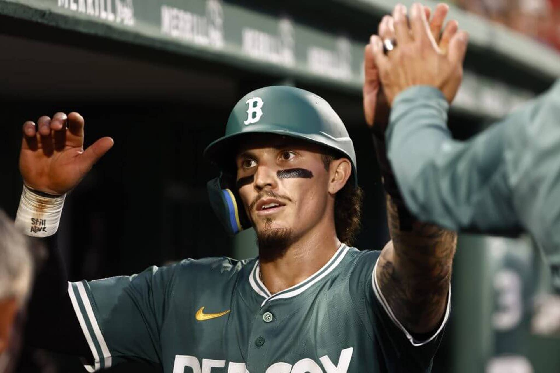 Jarren Duran high fives his teammates in the dugout after scoring against the Los Angeles Dodgers during a game in July.