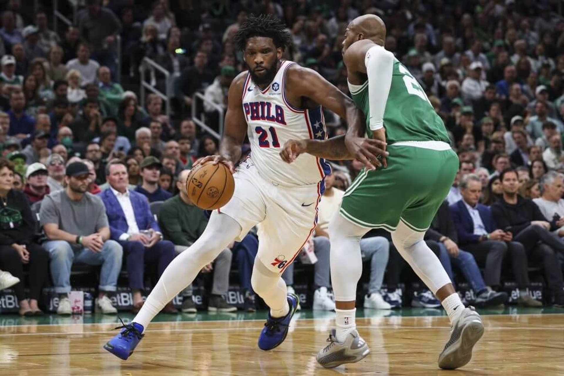 Joel Embiid dribbles against the Celtics.