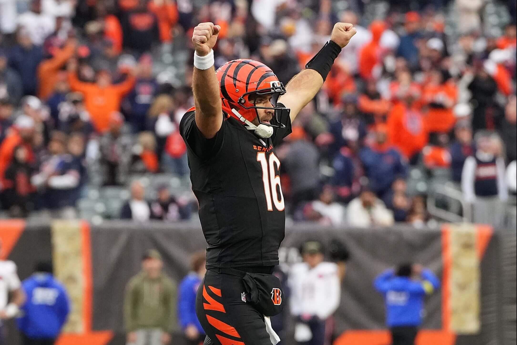 Bengals quarterback Joe Flacco, wearing a black No. 16 jersey, raises his arms up to celebrate a touchdown.