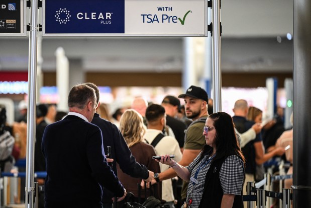 Travelers wait in line at a security checkpoint at George Bush Intercontinental Airport in Houston, Texas on November 7, 2025.