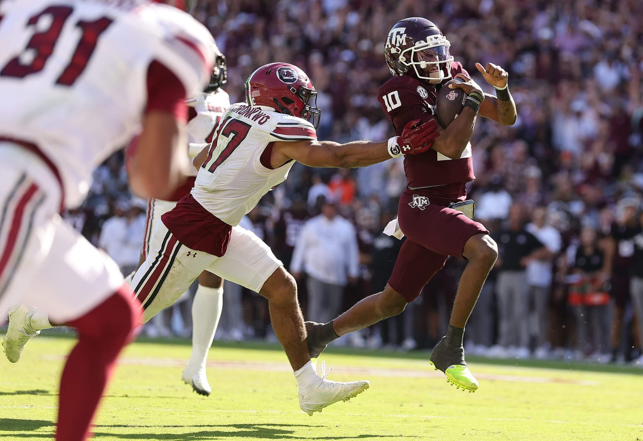 Chandler Morris runs past a defender who tries to tackle him.