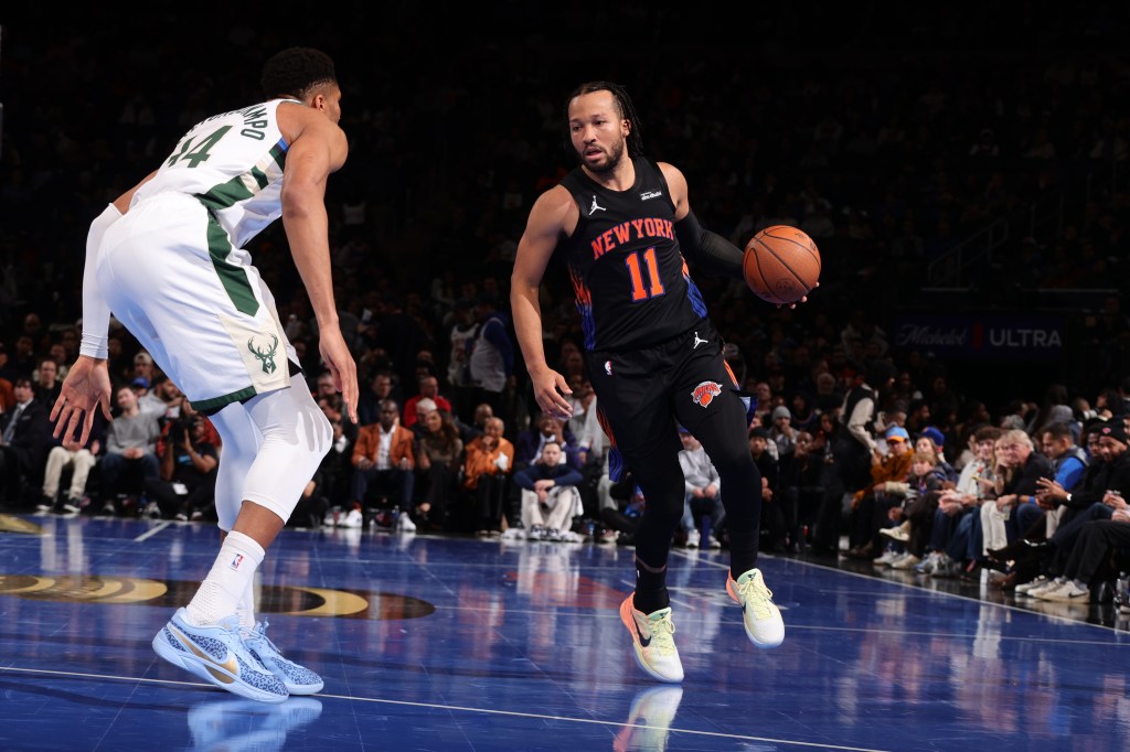 Jalen Brunson is guarded by Giannis Antetokounmpo.