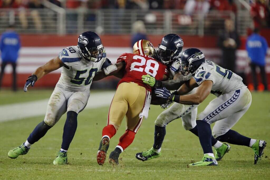 unning back Carlos Hyde #28 of the San Francisco 49ers is tackled on a 14-yard pass by safety Kam Chancellor #31 and linebacker K.J. Wright #50 of the Seattle Seahawks on the final play of the game