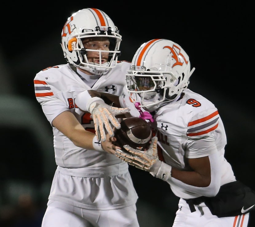 Rockwall quarterback Brent Rickert (2), left, hands off to running back Jacolby Hankins (9)...