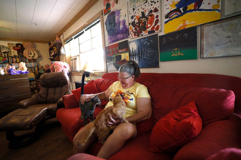 Yvonne Blackstock is seen with her cats, Lovely (left) and Sandwich (right), in her house on...