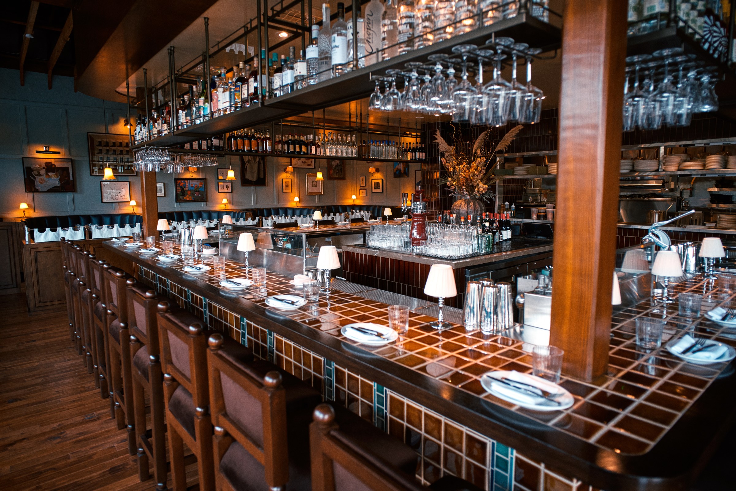 Tiled bar at Hermon’s with glasses hanging above and place settings