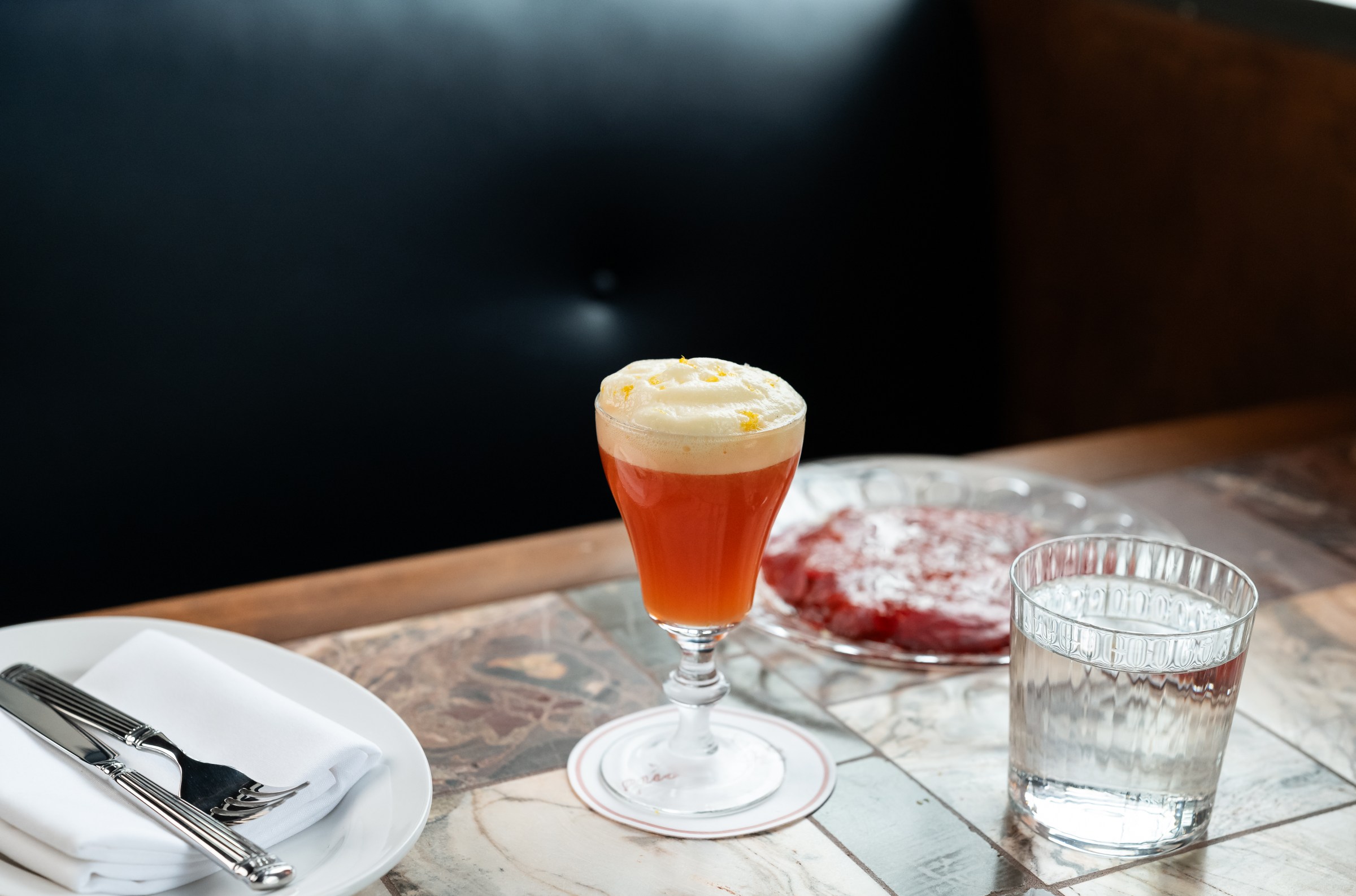 Garibaldi with bitter orange fluff on top sitting on a tiled bar
